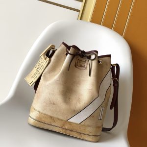 The iconic NOE handbag reimagined in WN leather for the Monogram Anniversary collection. Timeless beige hue. Monogram Jack lining and signature House motif with ultra-glossy brushed finish celebrating 130 years of distinctive luxury design. Gold-tone padlock and Louis Vuitton Paris stamp, crafted for true collectors.Dimensions: 27.5 x 36 x 20 cm (L x H x W). Features pearl-embossed leather inserts and "Louis Vuitton Paris" lettering. Includes one WN calf leather embroidered patch.Khaki leather trim. Capacity: Smartphone, headphones, coin purse, book, sunglasses, cosmetic case. Jacquard Monogram lining with gold-tone hardware. Shoulder strap: Detachable, adjustable length. Drawstring closure. Detachable commemorative emblem and (when shoulder-fixed) minimum strap length: 26.0 cm.Internal removable zippered monogram-patterned pouch. Maximum shoulder strap length (when fixed): 32.0 cm. Internal commemorative leather label. 2026 Spring/Summer Women's Handbag Crossbody Leather Bag. Region: Paris. Season: 2026 Spring/Summer. Brand: Louis Vuitton. Dimensions: 27.5 x 36 x 20 cm. Model: M27389.